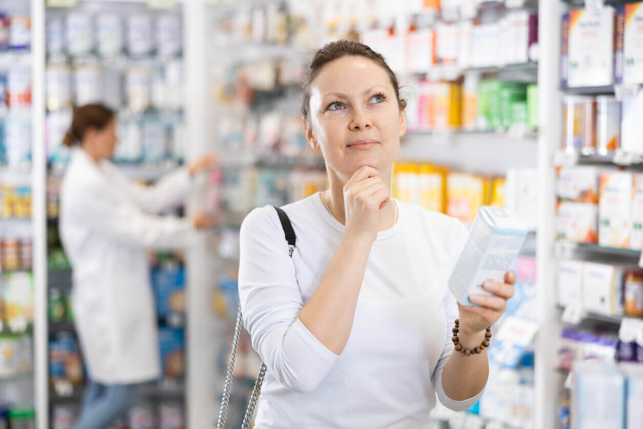 Imagem de mulher escolhendo probióticos em forma de suplemento na farmácia – Culturelle.