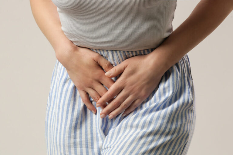 Mulher com desconforto abdominal representando problemas urinários e os possíveis benefícios dos probióticos para a saúde íntima